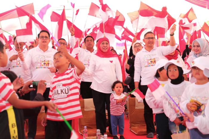 Khofifah Indar Parawansa berada di tengah anak-anak dengan membawa bendera Merah Putih