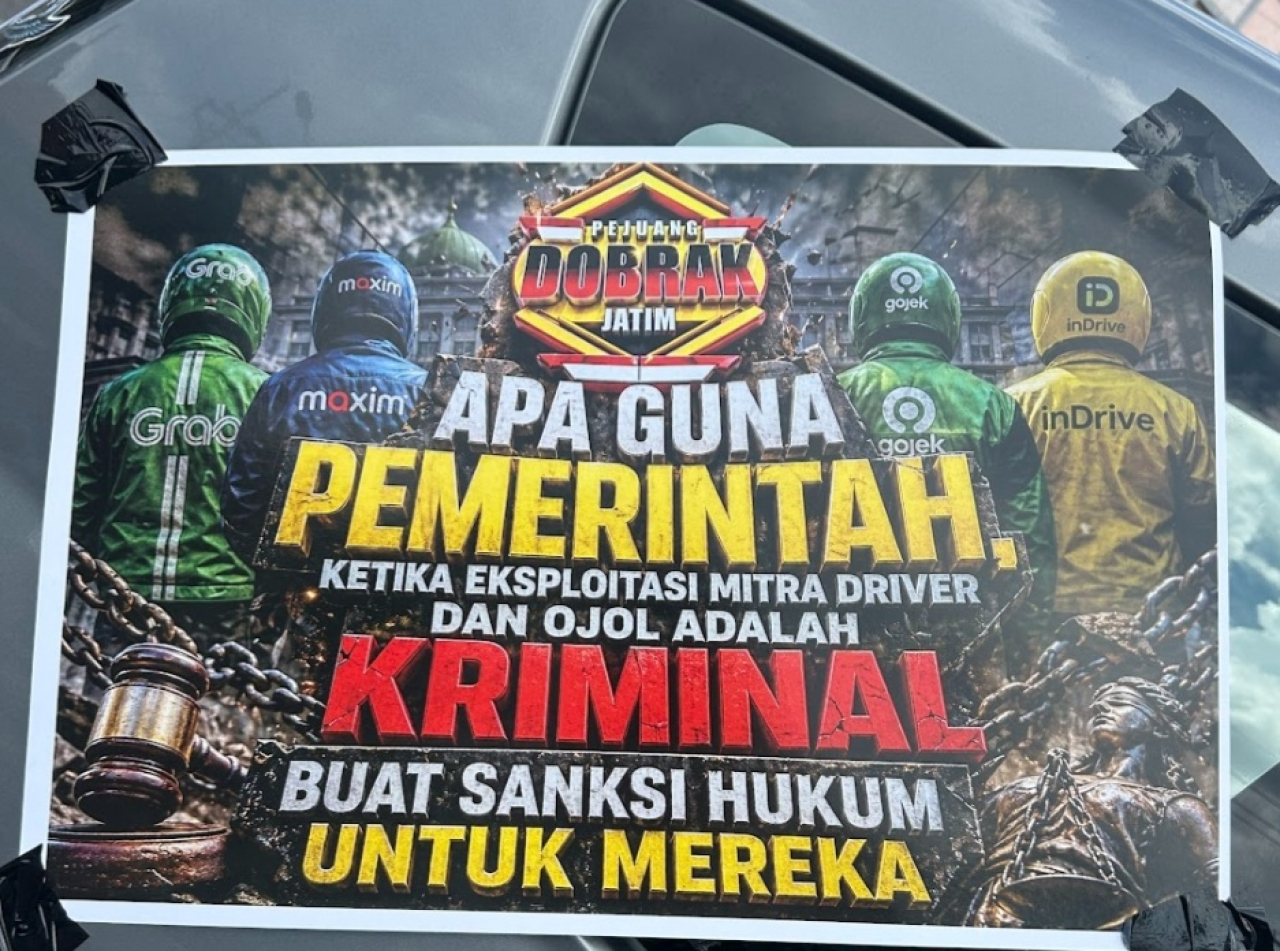 Salah satu poster dari massa driver ojek online (ojol) Jawa Timur saat menggelar aksi di depan Kantor DPRD Jatim, Jalan Indrapura, Surabaya, Selasa (28/4/2026). (Humas DPRD Jatim for Lingkaran.net)
