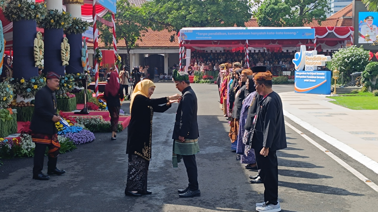 Gubernur Jawa Timur Khofifah Indar Parawansa menyerahkan Tanda Kehormatan Satyalancana Karya Satya kepada perwakilan pendidik dalam upacara Hardiknas 2026 di Gedung Negara Grahadi, Surabaya, Senin (4/5/2026).
