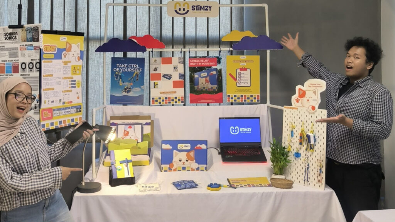 Yohanes Carolus Satria Bramantyo (kanan) dan Ivena Ayu Lestari saat memamerkan STIMZY pada Final Exhibition (Finalex) di Departemen Desain Komunikasi Visual (DKV) ITS. (Humas ITS)